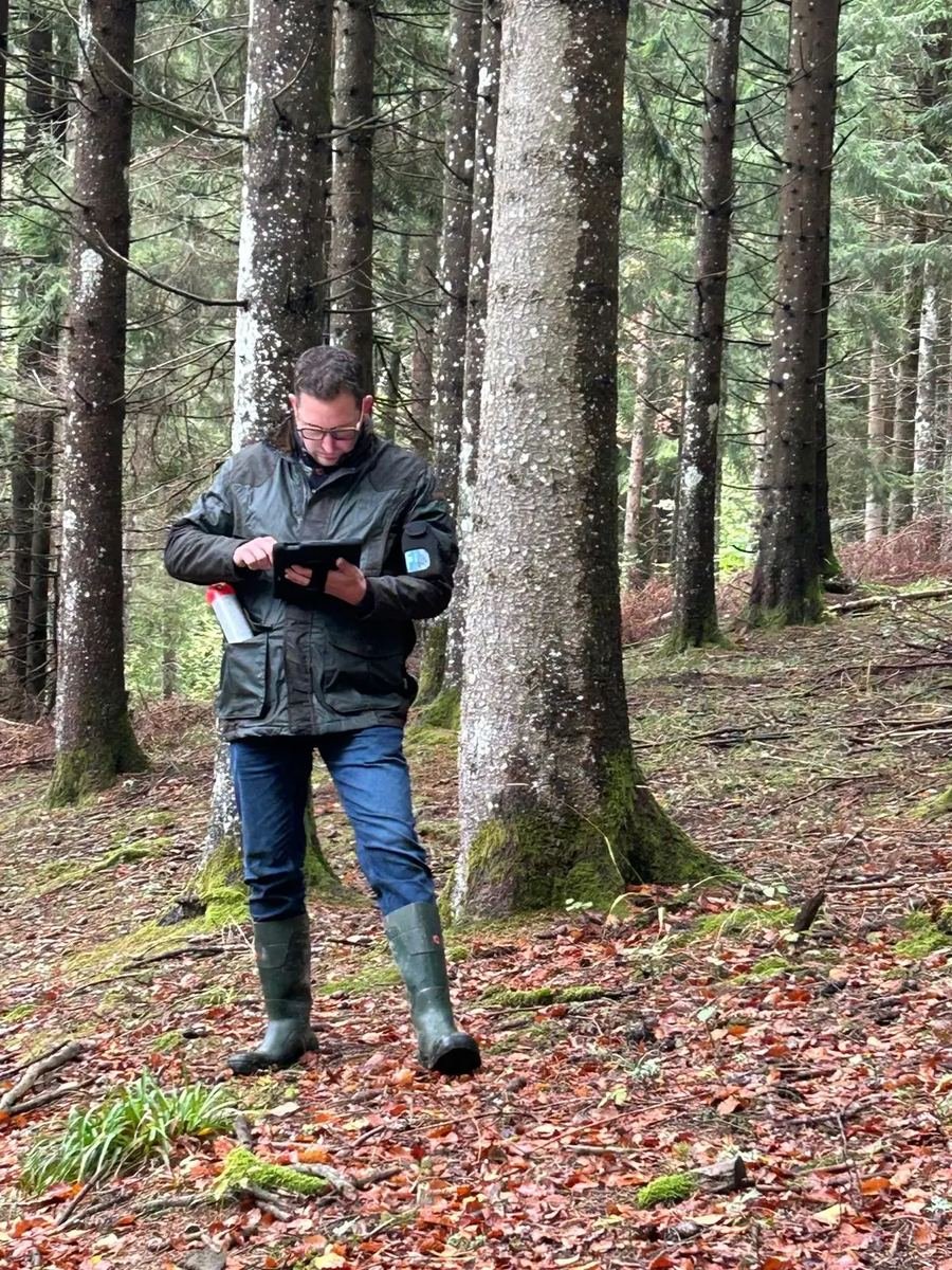 Loïc Conter réalisant un relevé forestier sur le terrain